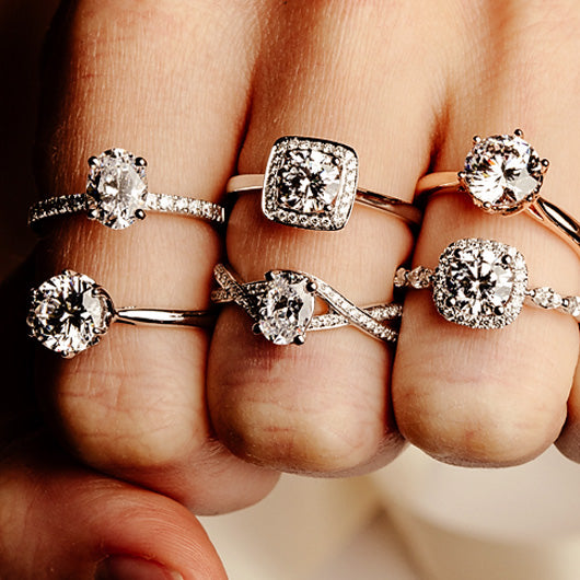 Macro photo of 3 fingers - each wearing 2 diamond rings